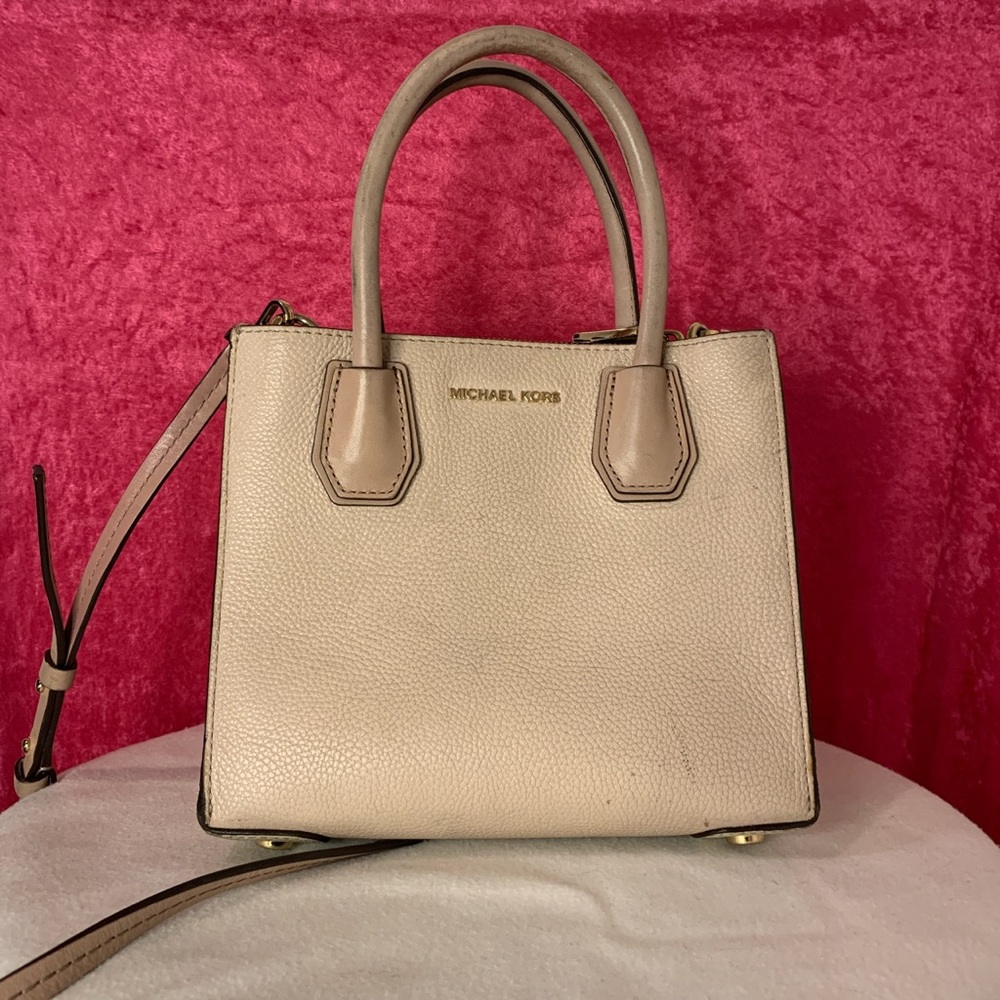 Light pink and cream colored Micheal kors bag.